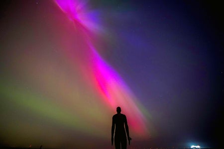 Human figure in front of aurora borealis
